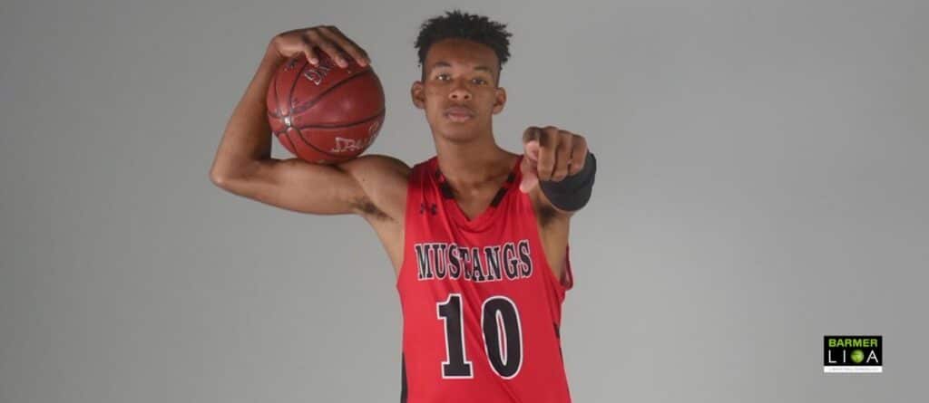 Basketballspieler der Mustangs trägt rotes Trikot Nummer 10 und hält Basketball.