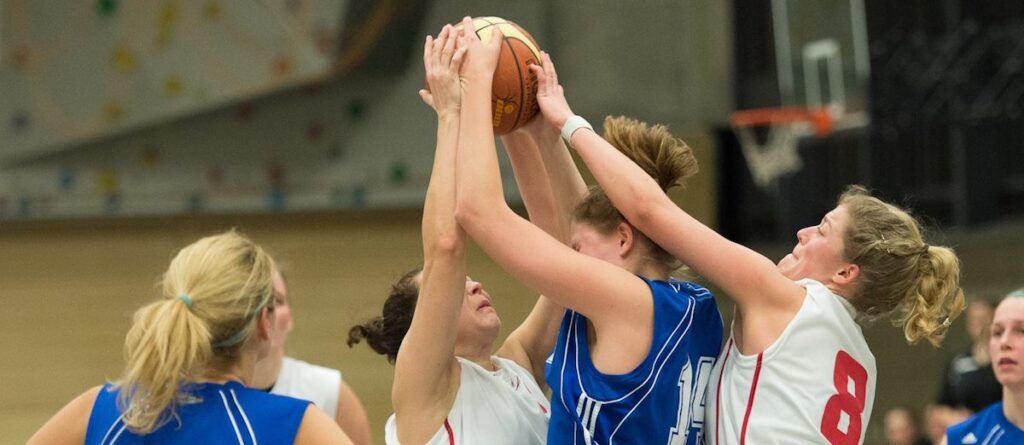 Mehrere Basketballspielerinnen der RheinStars Köln springen nach dem Ball.