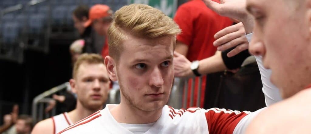 Junger Basketballspieler der RheinStars Köln in rotweiß gestreiftem Trikot in der Halle.