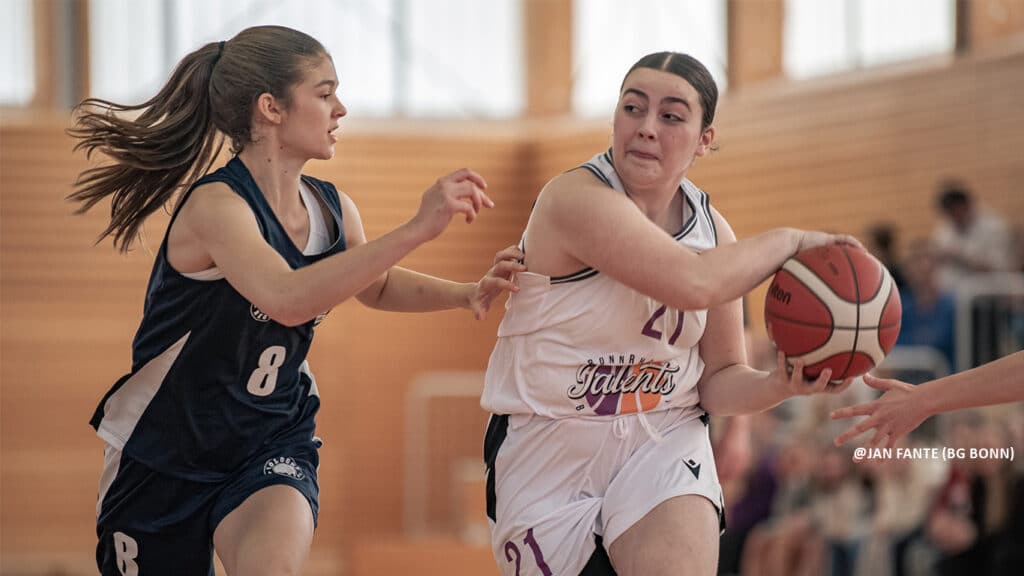 Basketballspielerin der RheinStars Köln mit Ball wird von Gegnerin mit Nummer 8 verteidigt.