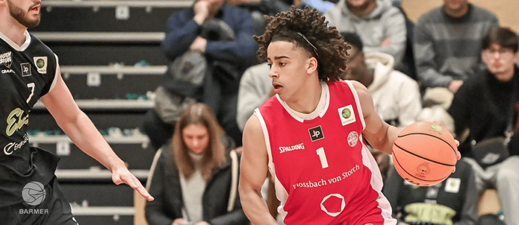 Basketballspieler der RheinStars Köln in rotem Trikot mit Nummer 1 dribbelt den Ball während eines Spiels.