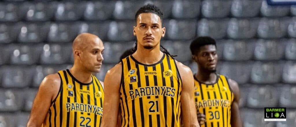 Drei Basketballspieler der Pardinyes in gelb-schwarzen Trikots stehen in einer Halle.