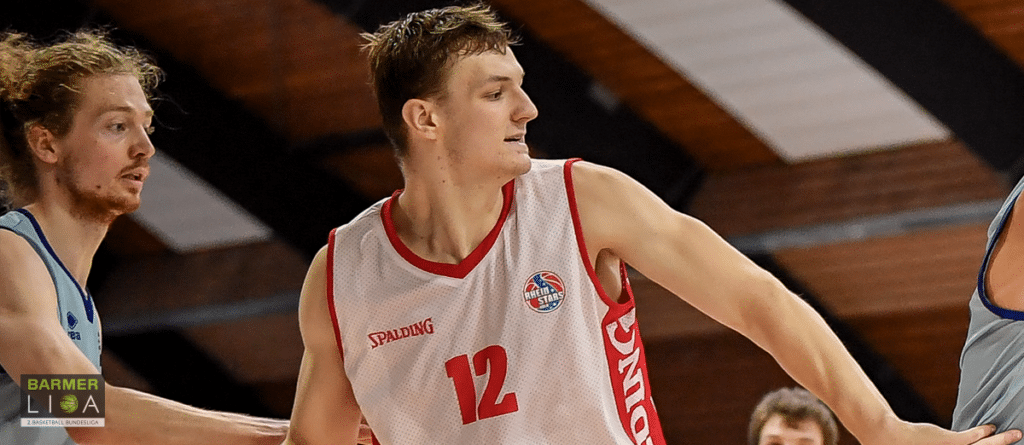 Basketballspieler der RheinStars Köln mit Nummer 12 in weißem Trikot während eines Spiels.