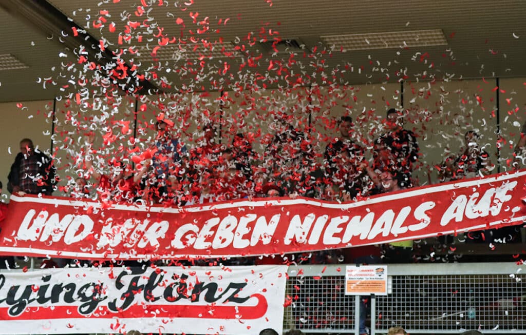 Konfettiregen in der Halle der RheinStars Köln mit rot-weißen Bannern und jubelnden Fans.