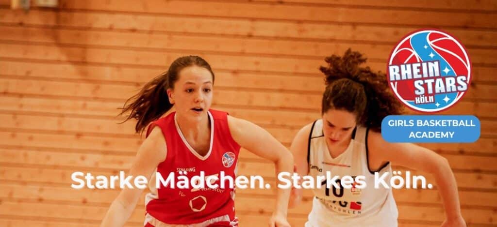 Zwei Basketballspielerinnen der RheinStars Köln Girls Basketball Academy trainieren in einer Sporthalle.
