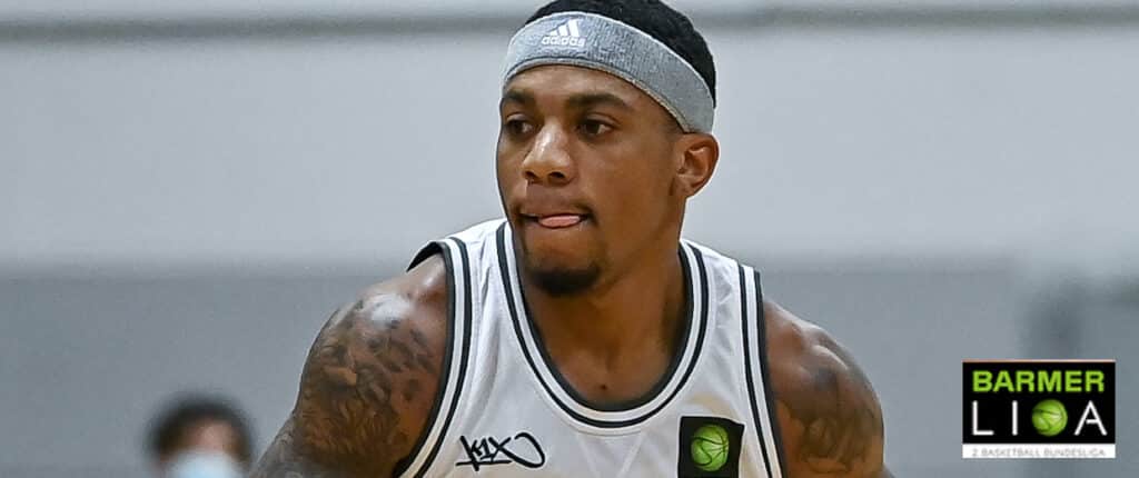 Basketballspieler der RheinStars Köln im weißen Trikot mit Stirnband während eines Spiels.