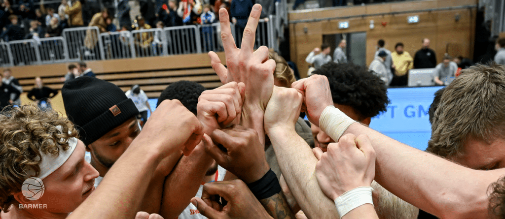 RheinStars Köln Team macht Victory-Geste in Sporthalle mit Publikum.