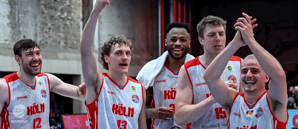 Fünf Basketballspieler der RheinStars Köln jubeln zusammen nach einem Sieg.