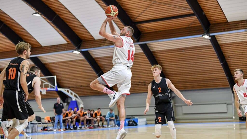 Basketballspieler der RheinStars Köln springt zum Wurf während eines Spiels in der Halle.