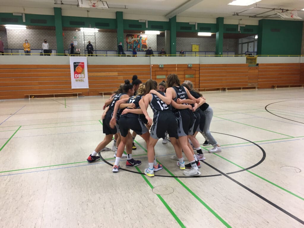 Basketballteam der RheinStars Köln im Motivationskreis in der Sporthalle.
