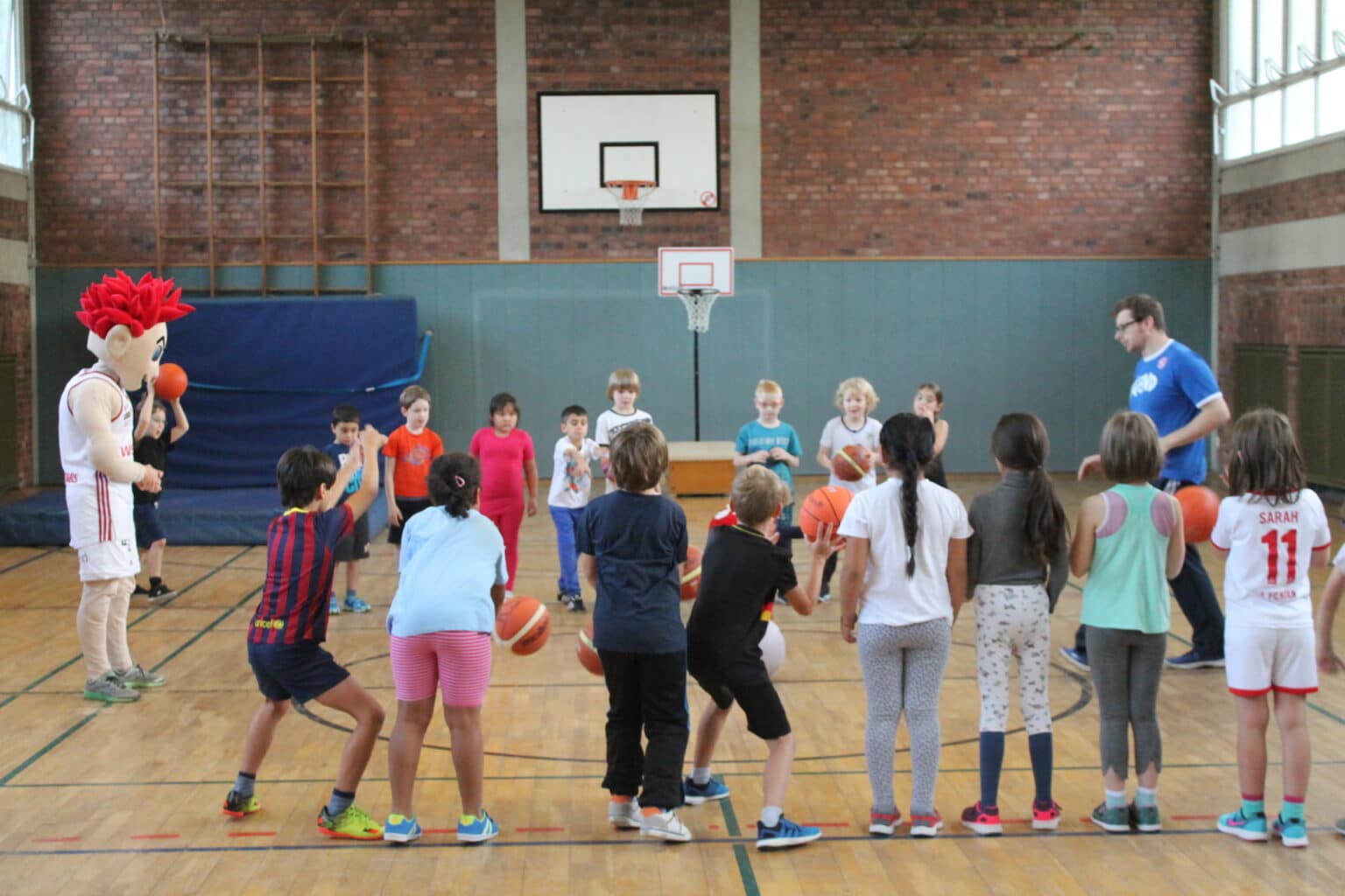 Basketballtraining der RheinStars Köln mit Kindern in einer Sporthalle.