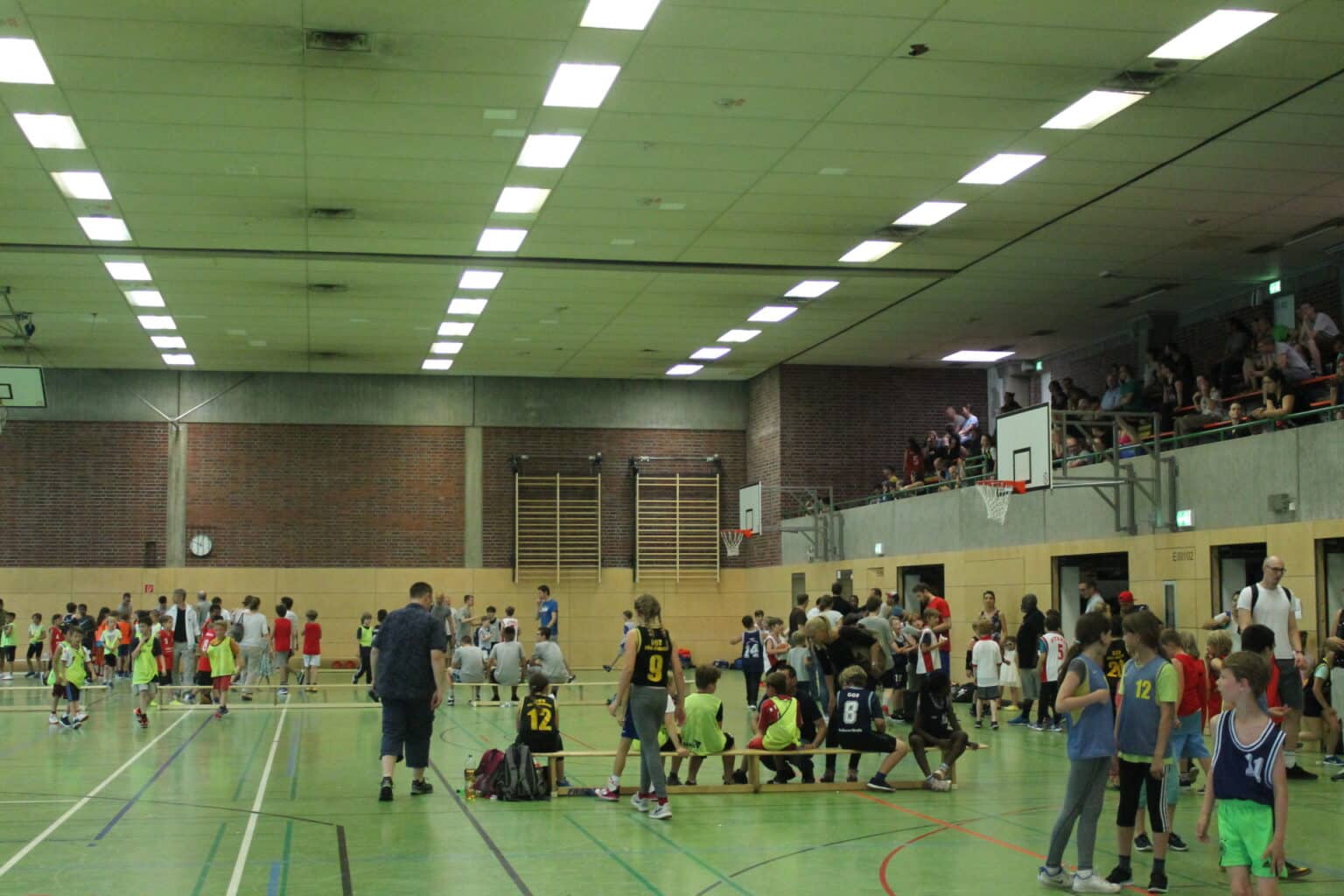 Sporthalle mit Basketballspiel der RheinStars Köln, Zuschauer auf der Tribüne.