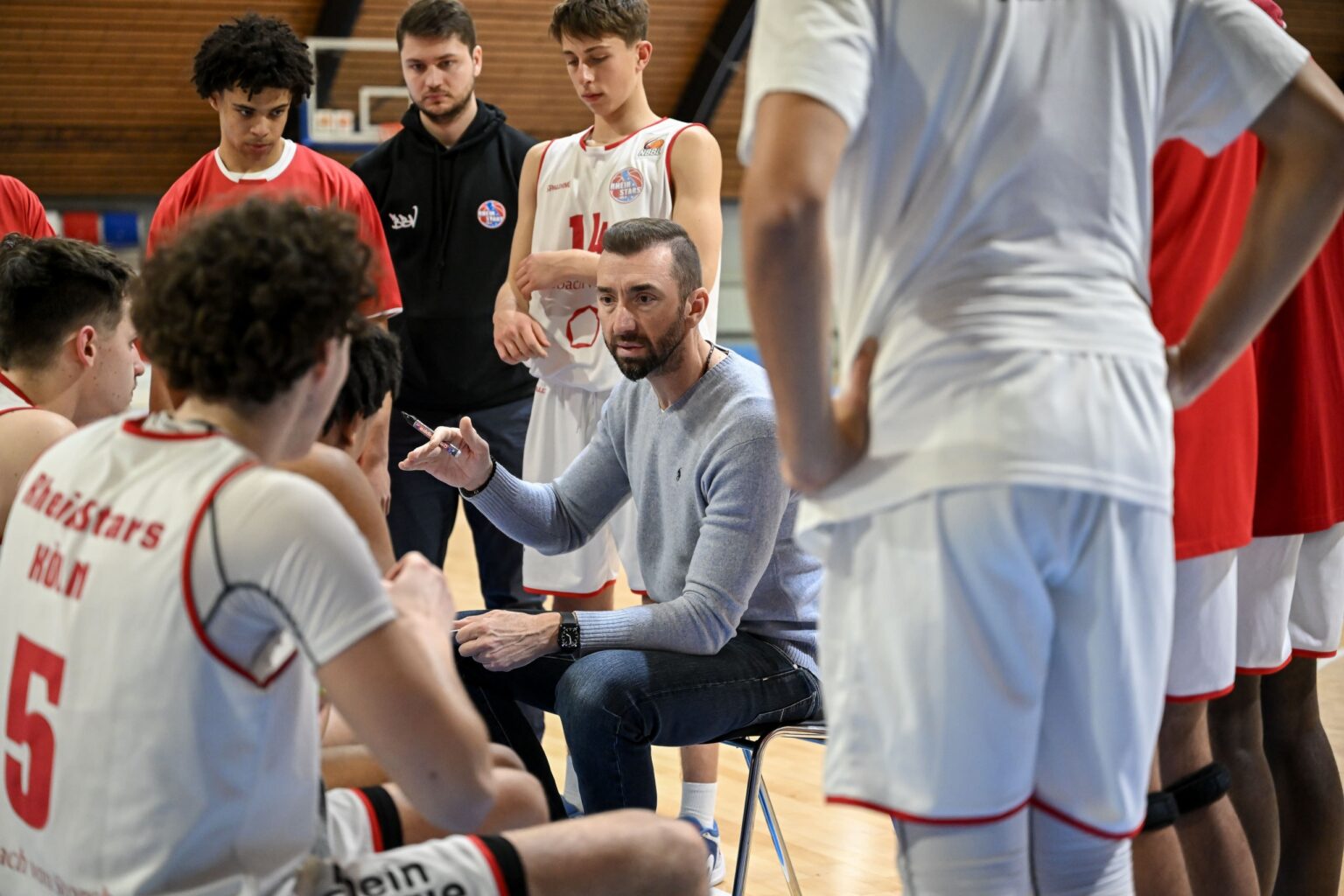 Trainer der RheinStars Köln erklärt Basketballspielern während Auszeit die Taktik.