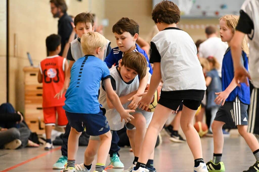 Kinder der RheinStars Köln trainieren zusammen in einer Sporthalle.