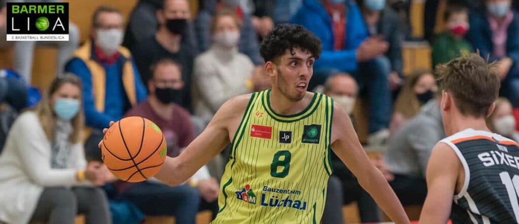 Basketballspieler der RheinStars Köln in gelbem Trikot mit Nummer 8 dribbelt den Ball während eines Spiels.