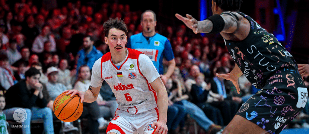 Basketballspieler der RheinStars Köln dribbelt während eines Heimspiels vor Publikum.