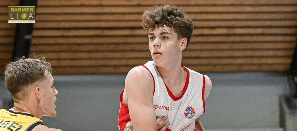 Junger Basketballspieler der RheinStars Köln in rotem Spalding-Trikot während eines Spiels.