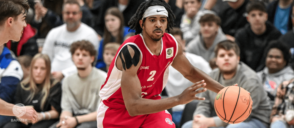 Basketballspieler der RheinStars Köln in rotem Trikot Nummer 2 dribbelt den Ball.