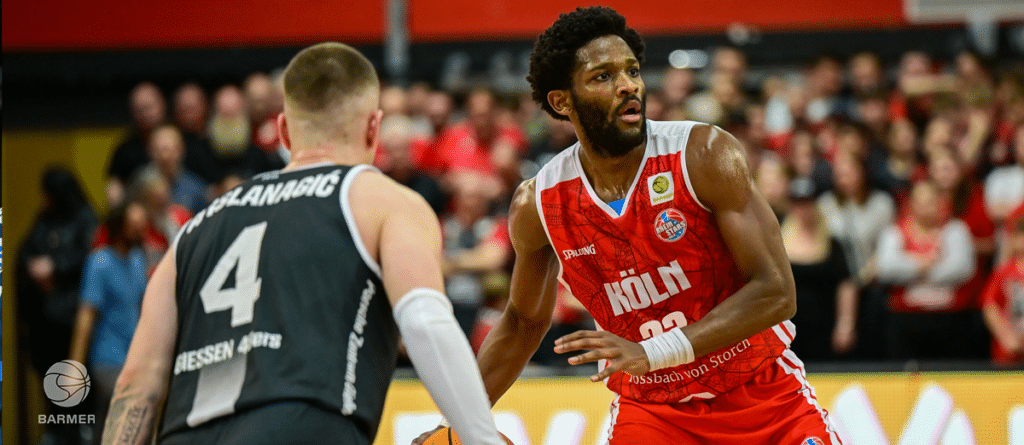 Basketballspieler der RheinStars Köln im roten Trikot während eines Spiels gegen Gießen.
