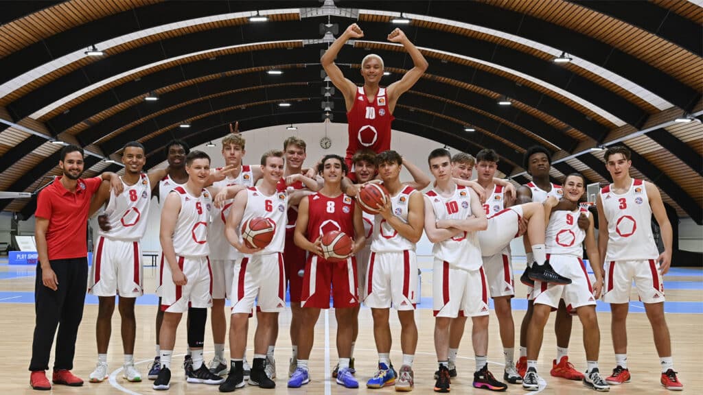 RheinStars Köln Basketballmannschaft posiert jubilierend in der Sporthalle.