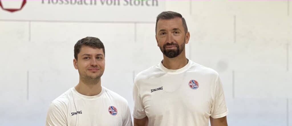 Zwei Spieler der RheinStars Köln in beigen Spalding-Trainingsshirts stehen nebeneinander.