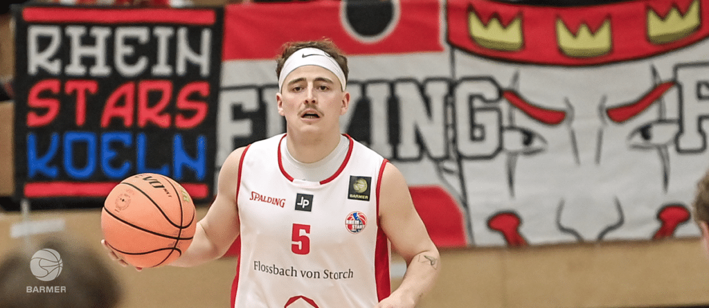 Basketballspieler der RheinStars Köln mit Nummer 5 beim Ballhandling in der Halle.