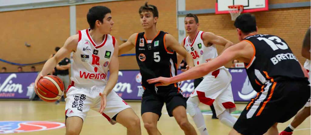 Basketballspiel der RheinStars Köln in Weiß gegen schwarzes Team in Sporthalle.