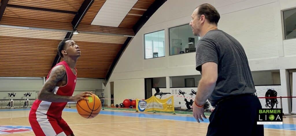 Zwei Personen spielen Basketball in einer Sporthalle der RheinStars Köln.