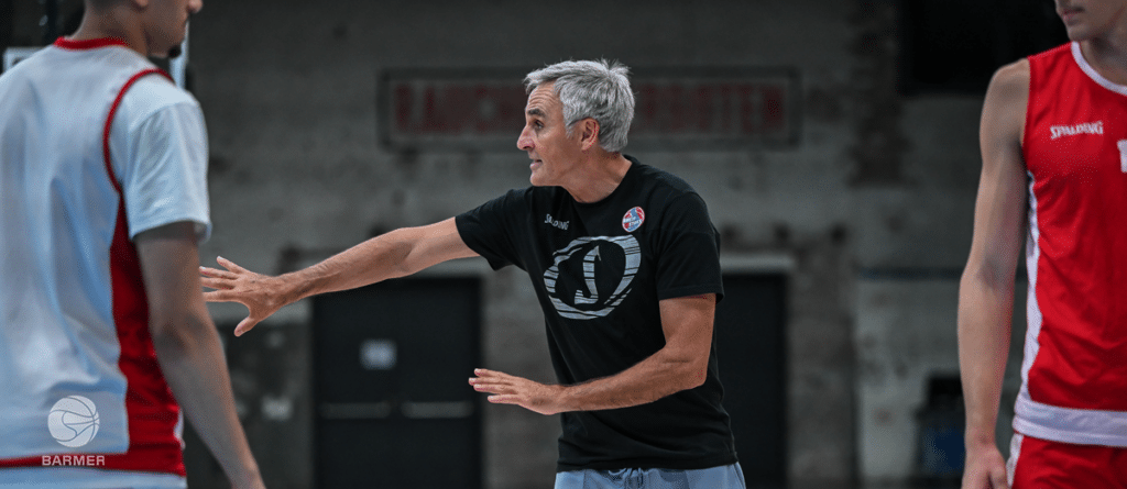Coach erklärt Spielern der RheinStars Köln eine Taktik in der Sporthalle.