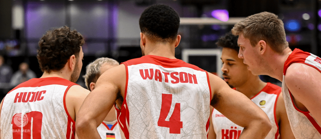 Basketballspieler der RheinStars Köln in Huddle-Formation während eines Spiels.