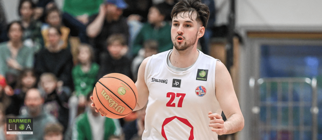 Basketballspieler der RheinStars Köln mit Nummer 27 dribbelt den Ball während eines Heimspiels.