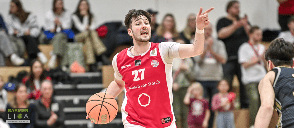 Basketballspieler der RheinStars Köln mit Nummer 27 dribbelt und gestikuliert während eines Spiels.