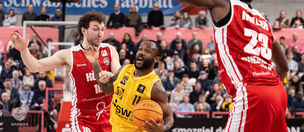 Basketballspiel der RheinStars Köln: Spieler in Gelb mit Ball gegen Gegner in Rot.