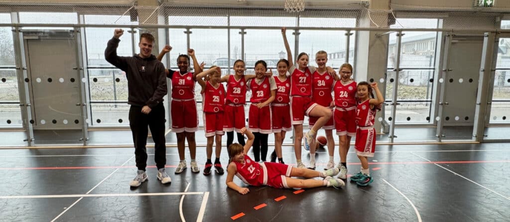 Basketballteam der RheinStars Köln jubelt in der Sporthalle.
