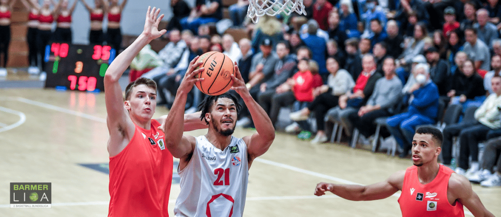 Basketballspiel der RheinStars Köln: Spieler in Weiß wirft mit Verteidiger in Rot.