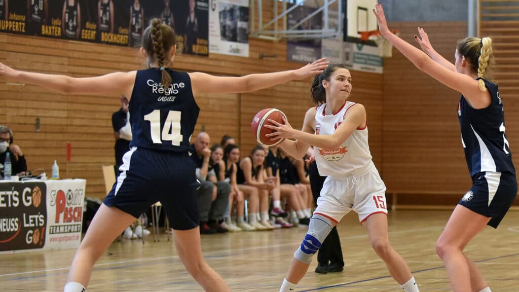 Basketballspiel der RheinStars Köln Ladies in der Sporthalle mit Spielerinnen in weißem und dunklem Trikot.