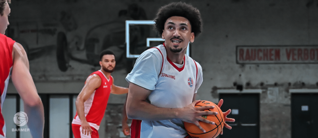 Basketballspieler der RheinStars Köln mit Ball in der Sporthalle.