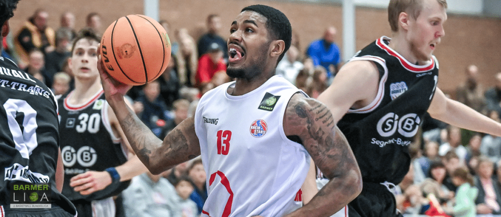 Basketballspieler der RheinStars Köln mit Nummer 13 hält Ball während Spiel.