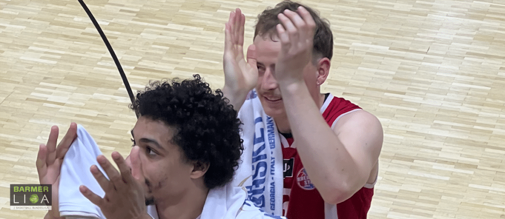 Zwei Basketballspieler der RheinStars Köln jubeln auf dem Spielfeld.