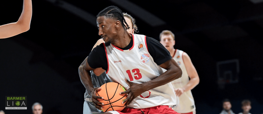 Basketballspieler der RheinStars Köln mit Nummer 13 dribbelt den Ball während eines Spiels.