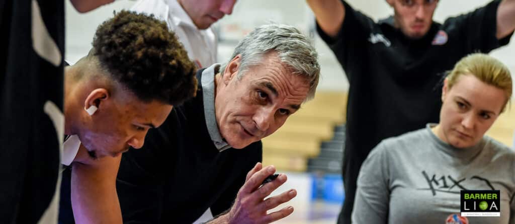 Ein Trainer der RheinStars Köln erklärt einem jungen Basketballspieler eine Spielzug-Strategie.