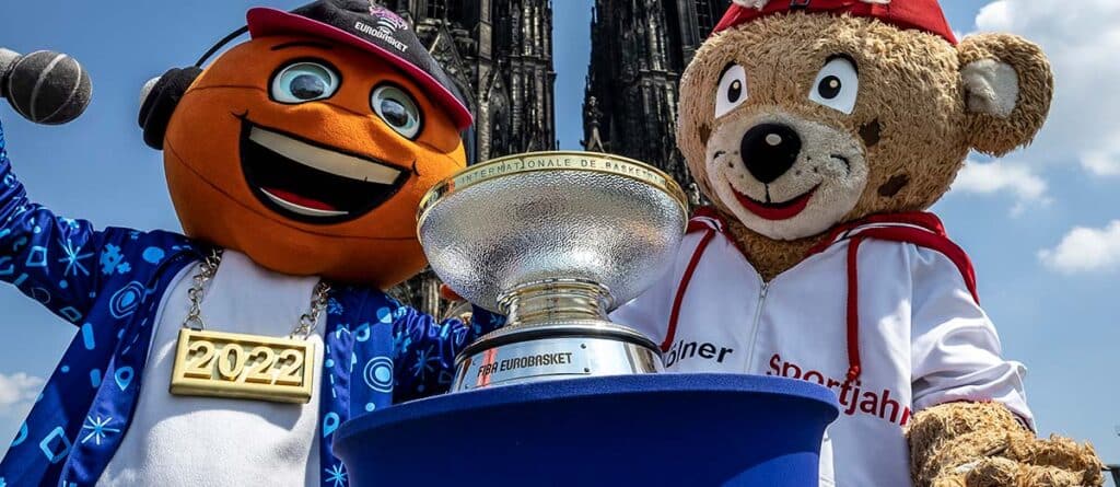 Zwei Maskottchen der RheinStars Köln präsentieren den EuroBasket-Pokal 2022 vor dem Kölner Dom.