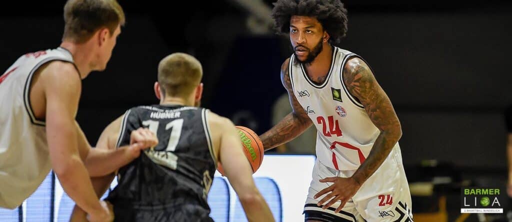 Basketballspieler der RheinStars Köln mit Nummer 24 dribbelt gegen Gegner in schwarzem Trikot.