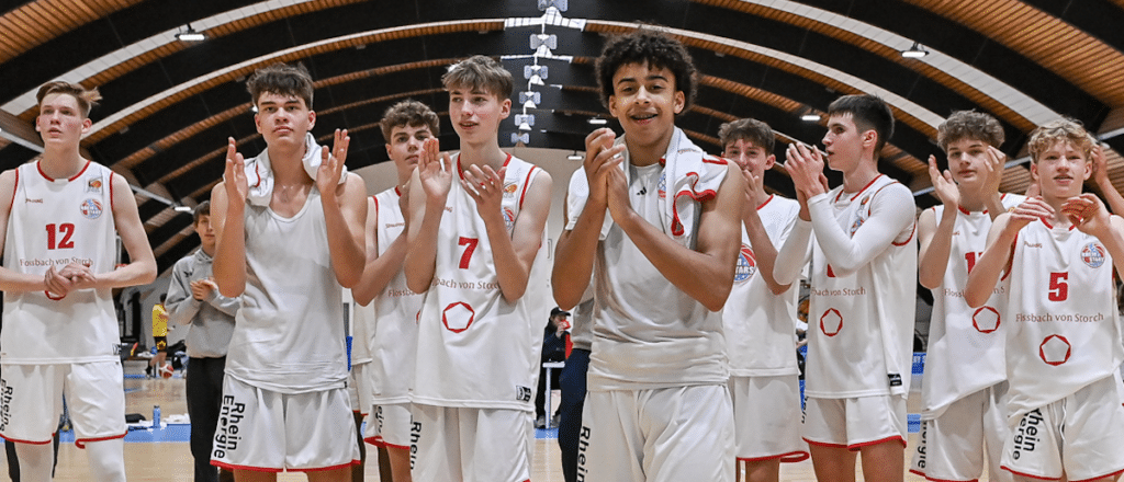 Basketballmannschaft RheinStars Köln applaudiert in Sporthalle.