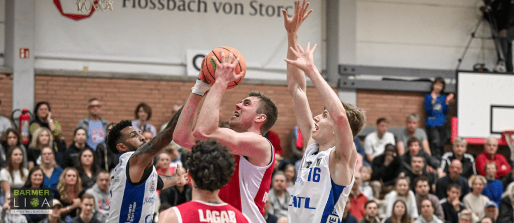 Basketballspiel der RheinStars Köln: Spieler in Rot und Blau kämpfen um den Ball.