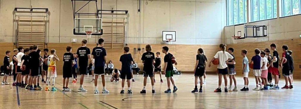 Basketballtraining der RheinStars Köln in einer Sporthalle mit Kindern und Jugendlichen.