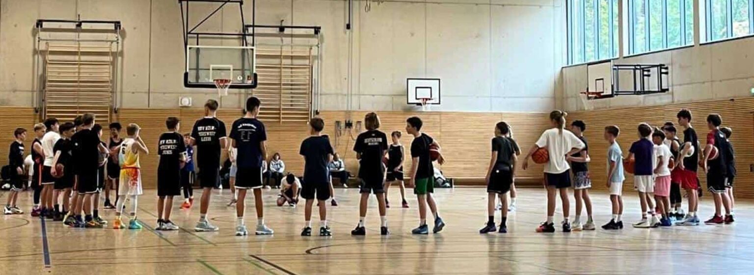Basketballtraining der RheinStars Köln in einer Sporthalle mit Kindern und Jugendlichen.