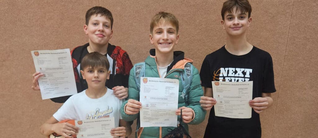 Fünf Jungen der RheinStars Köln halten stolz ihre Urkunden in die Kamera.