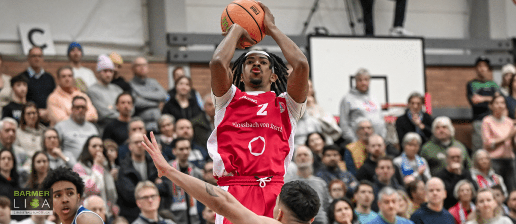 Basketballspieler der RheinStars Köln wirft Ball während Heimspiel vor Zuschauern.