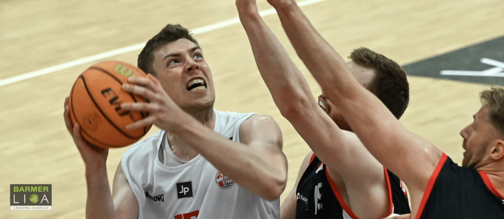 Basketballspieler der RheinStars Köln beim Wurf unter Druck der Verteidigung.